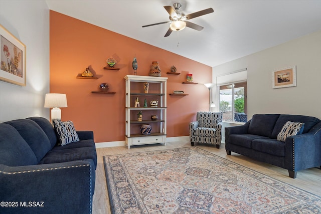 living room featuring baseboards, lofted ceiling, ceiling fan, and light wood-style flooring