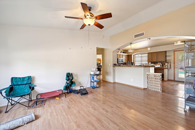 interior space with light wood-type flooring, vaulted ceiling, and ceiling fan