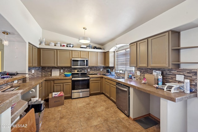 kitchen with pendant lighting, sink, vaulted ceiling, decorative backsplash, and appliances with stainless steel finishes