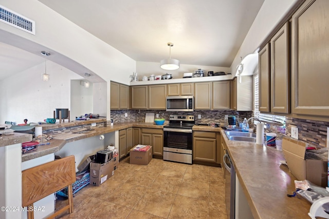 kitchen featuring decorative backsplash, sink, hanging light fixtures, and appliances with stainless steel finishes