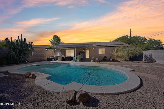 pool at dusk with a patio area