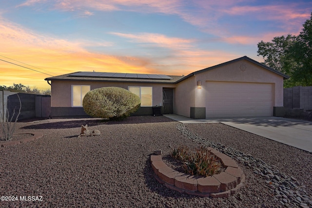 view of front of property featuring solar panels and a garage