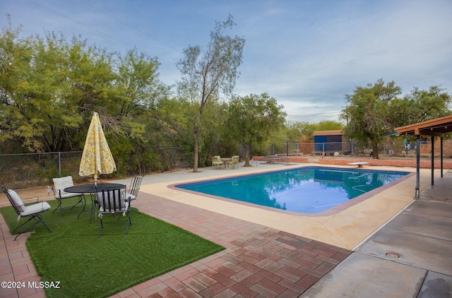 view of pool featuring a patio and a diving board