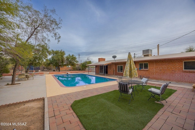 view of swimming pool with cooling unit and a patio