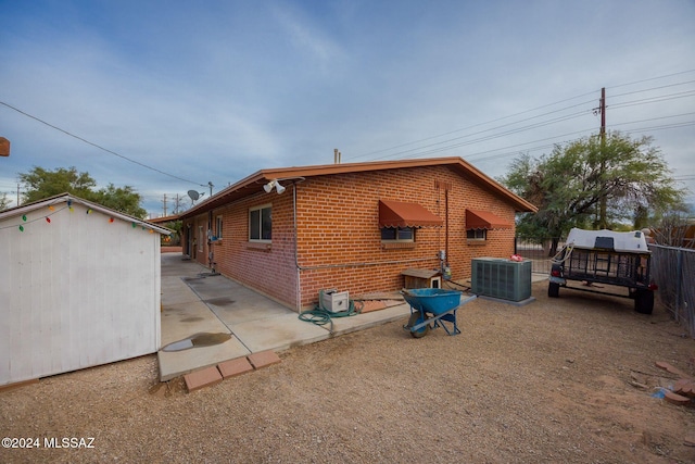 1440 W Roller Coaster Rd, Tucson, AZ 85704 - view of side of property featuring central air condition unit, brick siding, and an outdoor structure