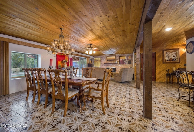 dining area with a fireplace, ceiling fan with notable chandelier, wooden ceiling, and wood walls