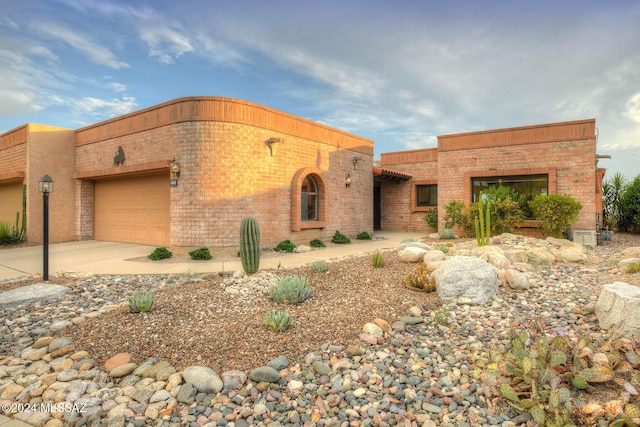 view of front facade featuring brick siding, concrete driveway, and a garage