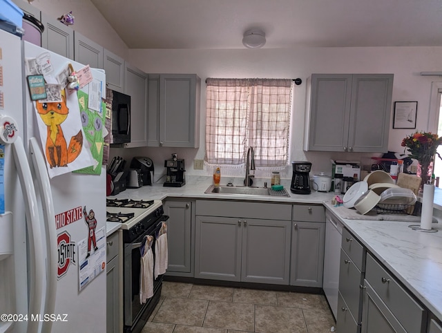 kitchen featuring gray cabinetry, black appliances, sink, light tile patterned floors, and light stone counters