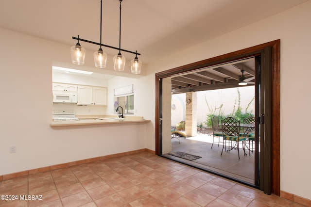 doorway featuring sink and light tile patterned floors