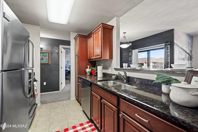 kitchen featuring light tile patterned flooring, a textured ceiling, stainless steel appliances, and sink