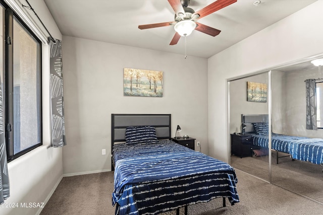 carpeted bedroom featuring ceiling fan, a closet, and multiple windows