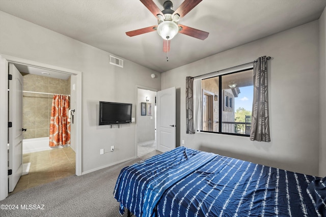 carpeted bedroom with ensuite bathroom and ceiling fan