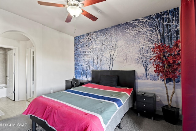 tiled bedroom with connected bathroom and ceiling fan