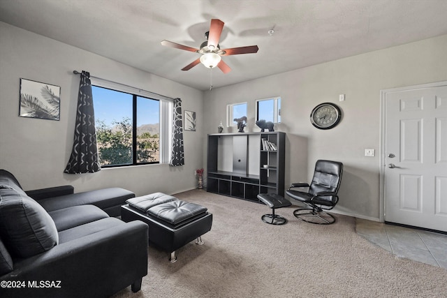 carpeted living room featuring a textured ceiling and ceiling fan