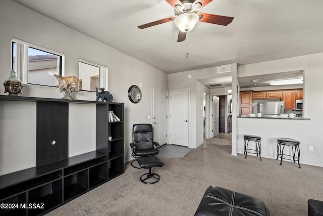 carpeted living room with ceiling fan