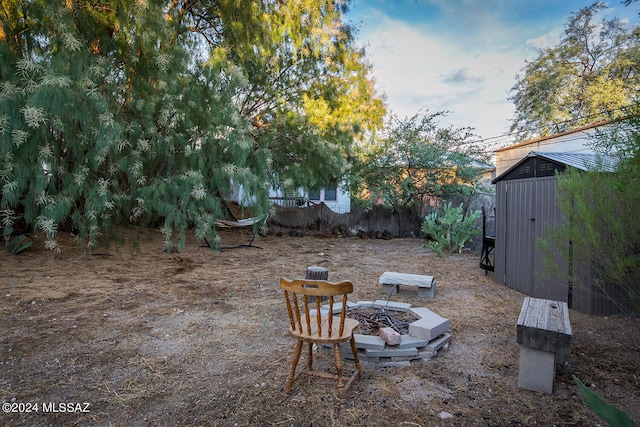 view of yard featuring a fire pit and a storage unit