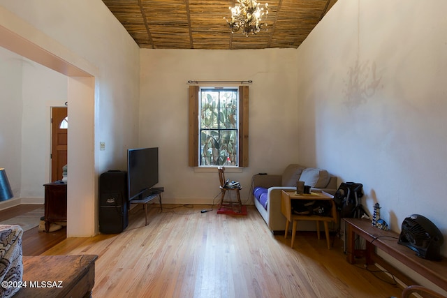 sitting room featuring light wood-type flooring, a notable chandelier, and wood ceiling