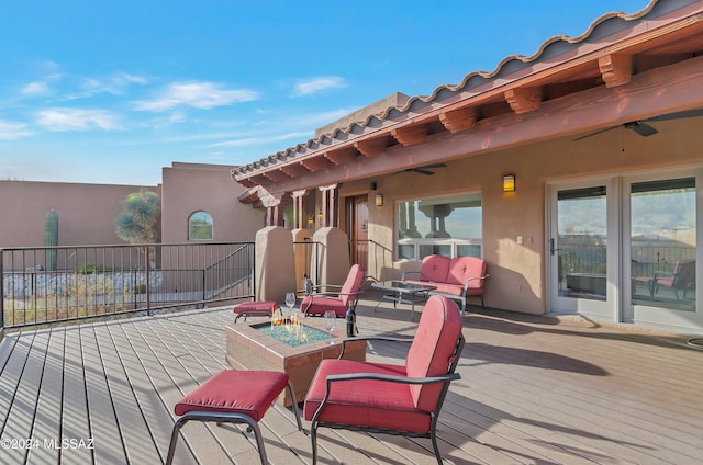 wooden deck featuring an outdoor living space with a fire pit