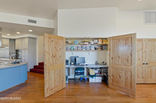 office with light wood-style floors, visible vents, a sink, and recessed lighting