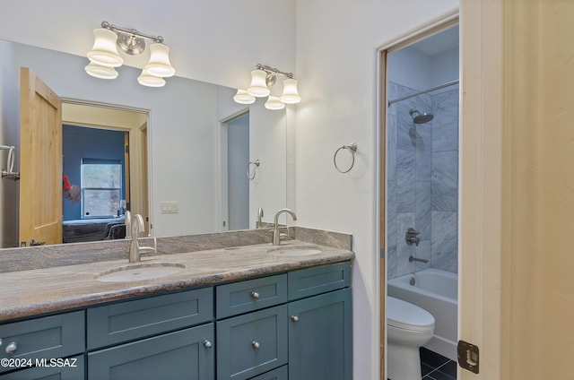 full bathroom with tiled shower / bath, vanity, toilet, and tile patterned floors