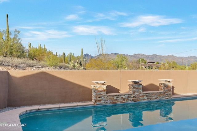 view of pool with a fenced in pool and a mountain view