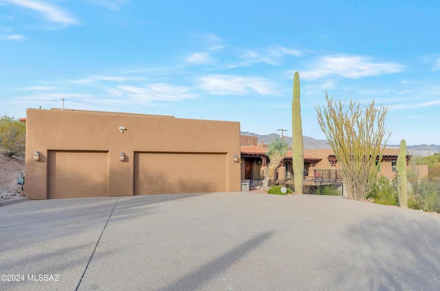4423 N Osage Dr, Tucson, AZ 85718 - pueblo revival-style home featuring a garage, a mountain view, and stucco siding