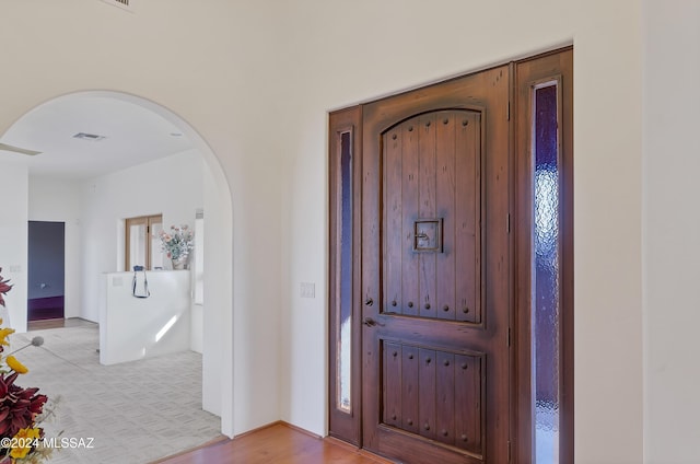 foyer featuring arched walkways and visible vents