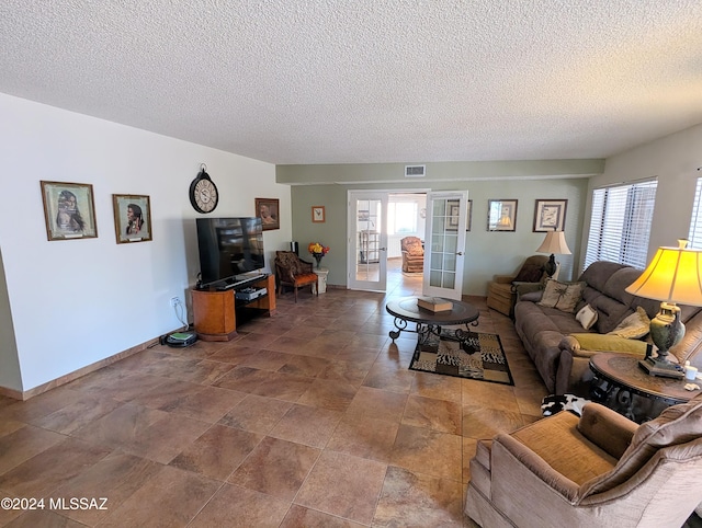 living room with french doors and a textured ceiling