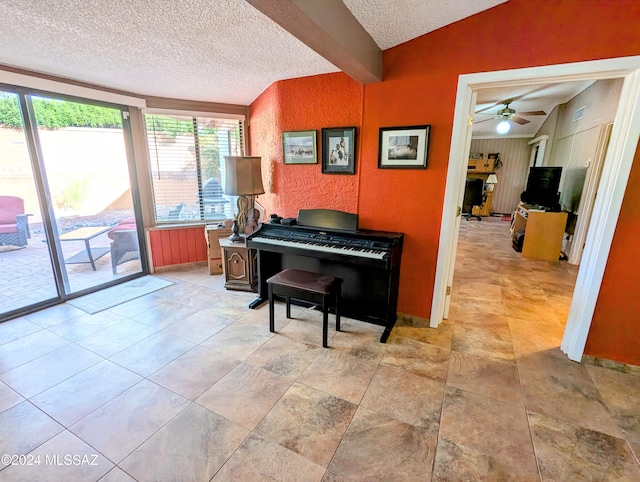 misc room featuring vaulted ceiling with beams, ceiling fan, and a textured ceiling