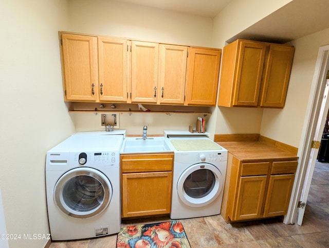 washroom featuring cabinets, washing machine and clothes dryer, and sink