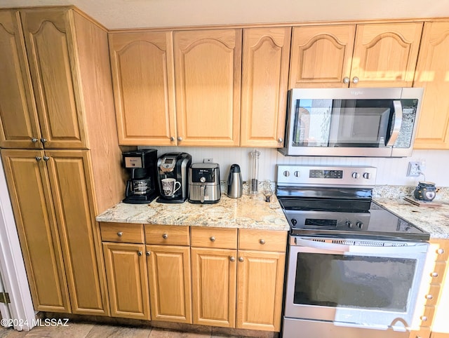 kitchen featuring light stone countertops and appliances with stainless steel finishes