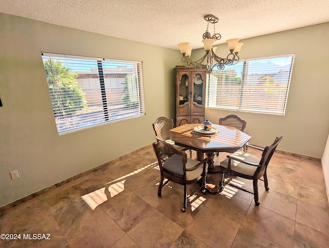 dining space featuring a chandelier and a textured ceiling