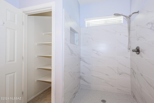 bathroom with tile patterned flooring and tiled shower