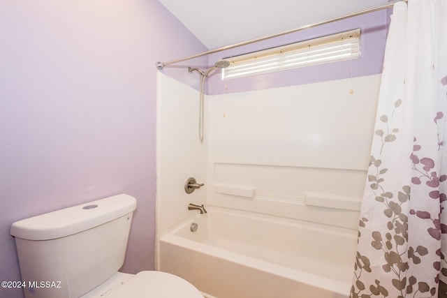 bathroom featuring shower / tub combo with curtain, vaulted ceiling, and toilet