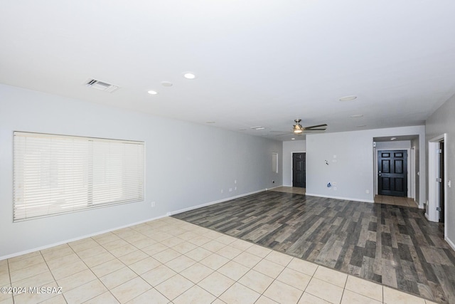 empty room with ceiling fan and light hardwood / wood-style floors