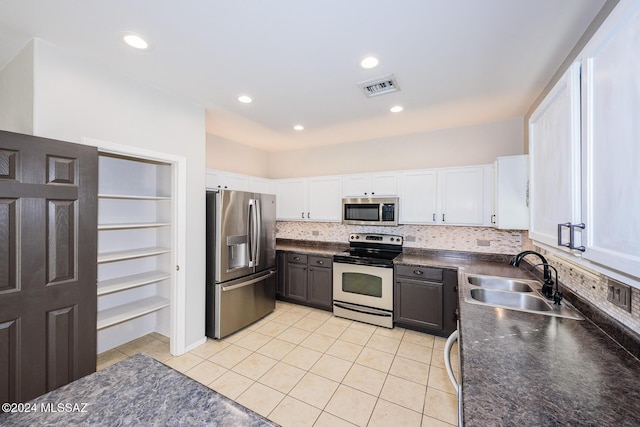 kitchen with light tile patterned flooring, white cabinetry, sink, and appliances with stainless steel finishes