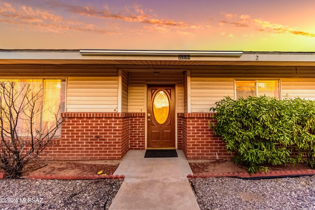 exterior entry at dusk featuring a porch