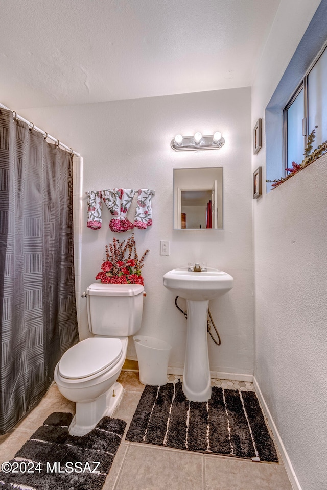 bathroom featuring tile patterned floors, curtained shower, sink, and toilet