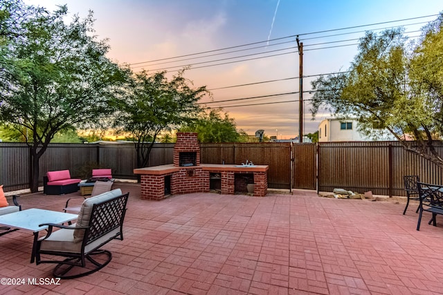 patio terrace at dusk with an outdoor brick fireplace