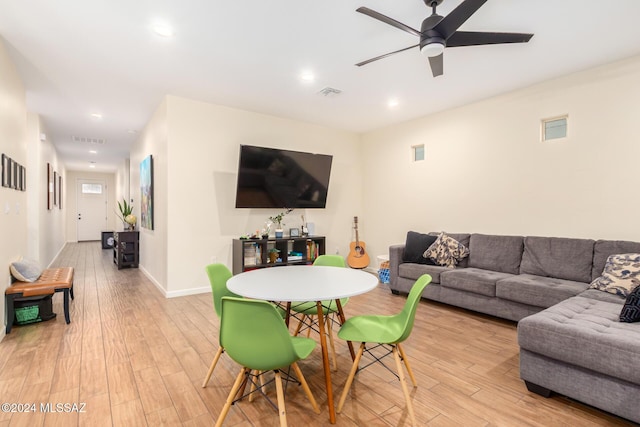 living room featuring ceiling fan and light hardwood / wood-style floors