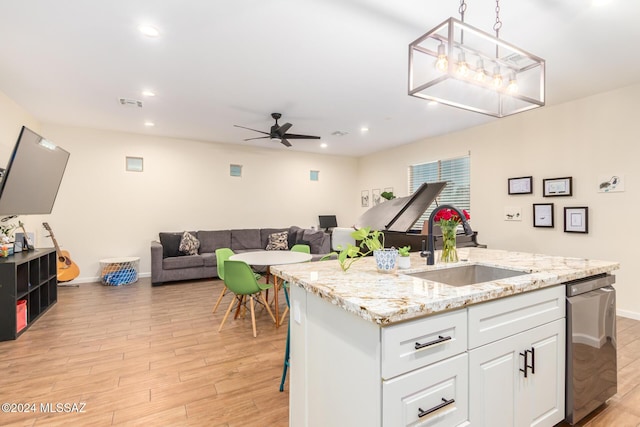 kitchen featuring sink, pendant lighting, light hardwood / wood-style floors, a kitchen island with sink, and white cabinets