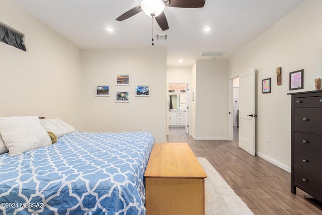 bedroom with light wood-type flooring, ensuite bathroom, and ceiling fan