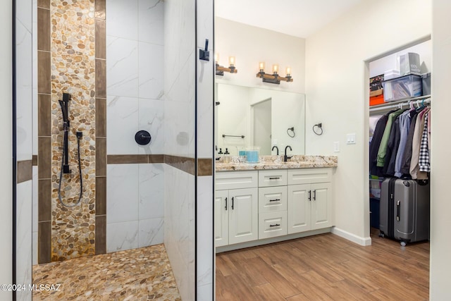 bathroom featuring a tile shower, hardwood / wood-style floors, and vanity