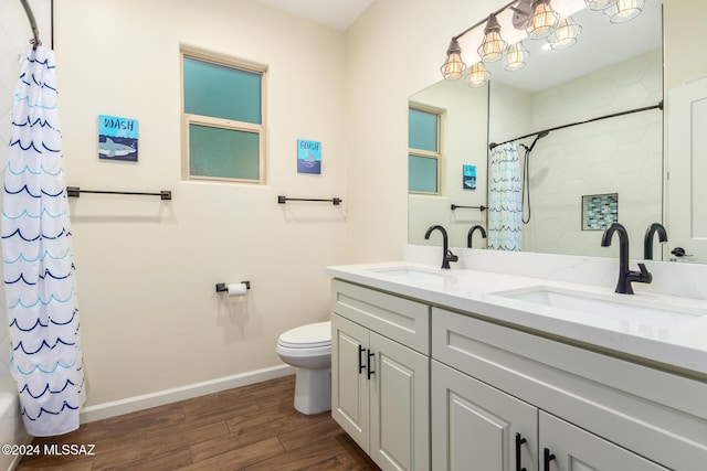 full bathroom featuring hardwood / wood-style floors, vanity, toilet, and shower / tub combo