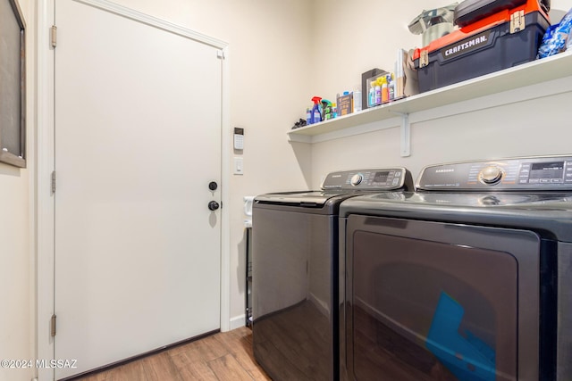 clothes washing area featuring light hardwood / wood-style floors and independent washer and dryer