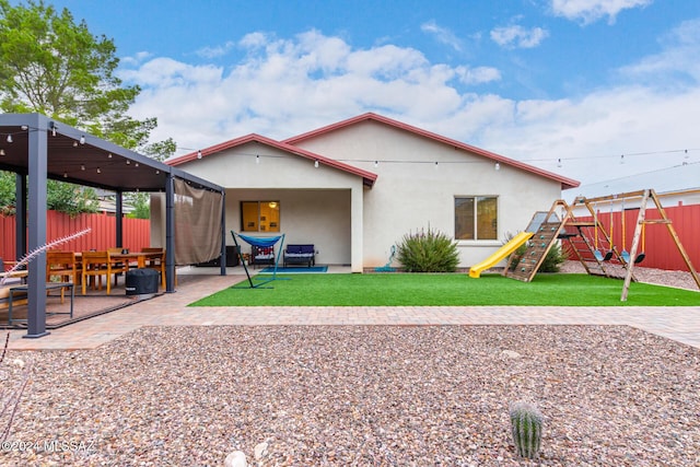 back of house featuring a playground and a patio