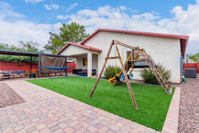 view of jungle gym featuring a lawn, an outdoor living space, cooling unit, and a patio