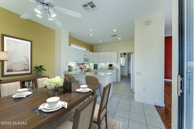 tiled dining space with ceiling fan