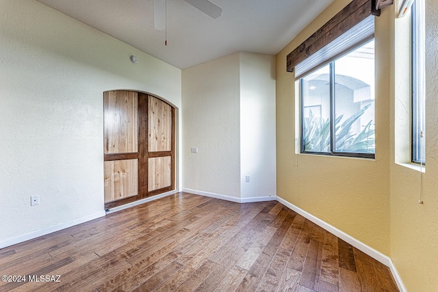 empty room with hardwood / wood-style flooring and ceiling fan