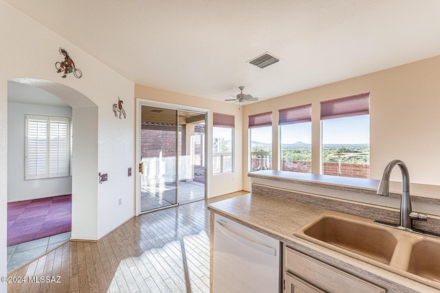 kitchen with sink, white appliances, light hardwood / wood-style floors, a kitchen island, and light brown cabinets